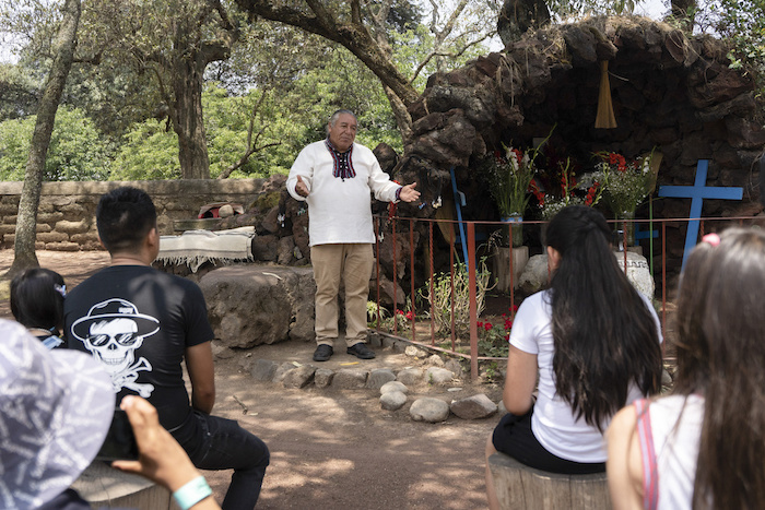 Moisés Vega cuenta la historia del volcán Popocatépetl a turistas, junto a una réplica del santuario que los pobladores han dedicado al volcán, en el Museo del Volcán en Amecameca, México, el domingo 11 de junio de 2023. Vega, un "granicero", también trabaja como un sanador tradicional.