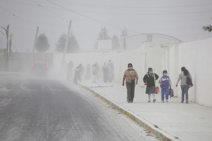 Pobladores caminan sobre las calles cubiertas de ceniza de San Andrés Cholla, México, el 18 de abril de 2016, después de que el volcán Popocatépetl hiciera erupción durante la noche, expulsando ceniza sobre los pueblos vecinos. La sabiduría sagrada sobre "El Popo" varía de pueblo a pueblo, pero la mayoría coincide en que el volcán no supone un riesgo para sus vidas.