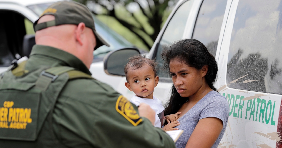 Una mujer proveniente de Honduras sostiene a su hijo de 1 año mientras se entrega a un agente de la Patrulla Fronteriza tras cruzar ilegalmente la frontera de Estados Unidos con México, el lunes 25 de junio de 2018, cerca de McAllen, Texas. Foto: David J. Phillip, Archivo, AP
