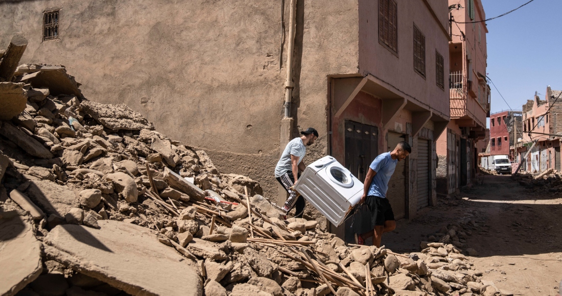 Dos personas recuperan una lavadora de su casa dañada por un sismo en la localidad de Amizmiz, cerca de Marrakech, Marruecos, el domingo 10 de septiembre de 2023.