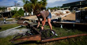 Jessica Long trata de sacar la bicicleta de su sobrina de debajo de un trozo de la vivienda vacacional de la familia, que quedó destrozada por la marejada ciclónica causada por Idalia, en Horseshoe Beach, Florida, el 31 de agosto de 2023, un día después del paso del huracán. Foto: Rebecca Blackwell, AP