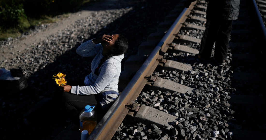 Una mujer migrante sentada al lado de las vías del tren con la esperanza de subirse a un tren de mercancías con ruta al norte en Huehuetoca, México, el miércoles 20 de septiembre de 2023.