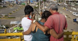 Pobladores, en un paso elevado, miran los daños causados por el huracán "Otis". Foto: Félix Márquez, AP. 
