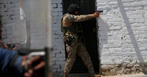 Un oficial de policía apunta con su arma a partidarios del derrocado presidente peruano Pedro Castillo durante una protesta contra su detención, en Chao, Perú, el 15 de diciembre de 2022. La ONU publicó un informe el 19 de octubre de 2023 que revela que las fuerzas de seguridad peruanas violaron los derechos humanos, utilizaron armas de fuego y cometieron torturas durante las manifestaciones que exigían la renuncia de la presidenta Dina Boluarte y miembros del Congreso que dejaron más de 50 muertos, tras el derrocamiento de Castillo. (AP Foto/Hugo Curotto, Archivo)