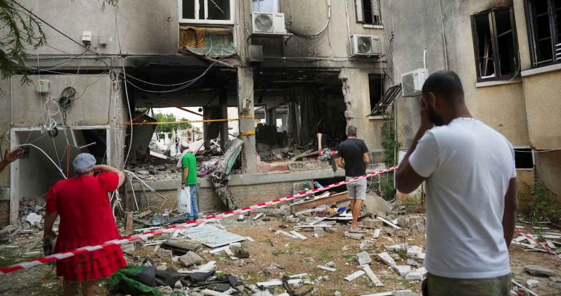 Varios israelíes inspeccionan un edificio residencial dañado que se vio alcanzado por un cohete lanzado desde la Franja de Gaza, en Ashkelon, Israel, el lunes 9 de octubre de 2023.