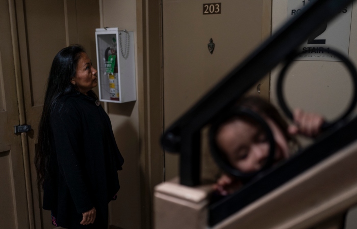 La madre de Deneffy espera afuera del apartamento de su amiga con el fin de pedirle prestada la cocina para prepararle alimentos a su hija Jennifer. 