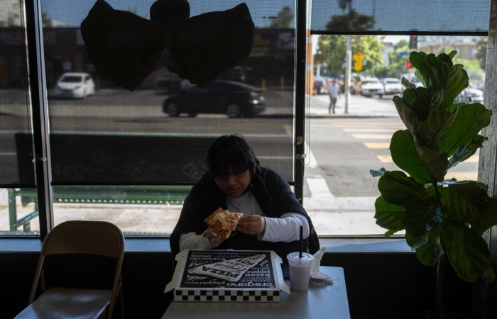 Deneffy Sánchez come pizza después de la escuela. 