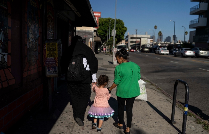 Deneffy Sánchez y su hermanita, Jennifer, se dan la mano para cruzar la calle y comprar bebidas frías. Foto: Jae C. Hong, AP