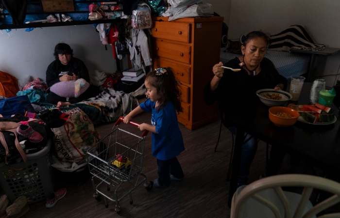 Deneffy Sánchez observa su smartphone en una litera en la que duerme con su madre, Lilian López, y su hermana, Jennifer, en un apartamento tipo estudio que comparten con otras personas.
