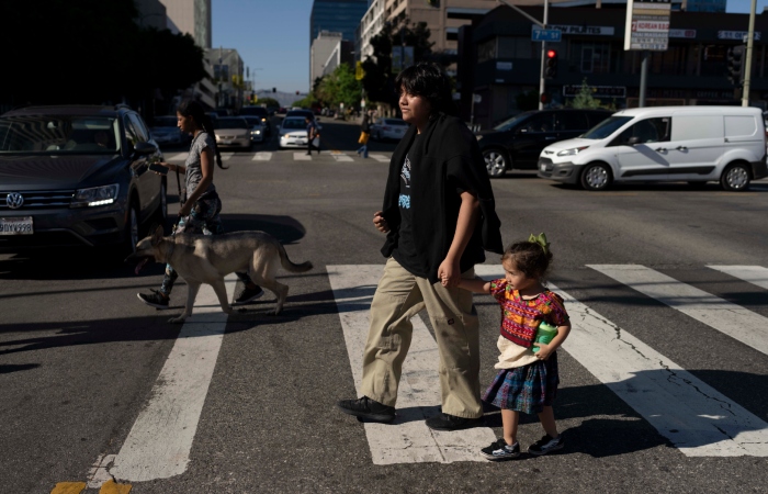Deneffy Sánchez y su hermanita, Jennifer, se dan la mano para cruzar la calle y comprar bebidas frías. 