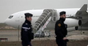 Gendarmes patrullan junto a un avión detenido por la policía por sospechas de que podría llevar a víctimas del tráfico de personas, en el aeropuerto de Vary, este de Francia, el lunes 25 de diciembre de 2023. (AP Foto/Christophe Ena)