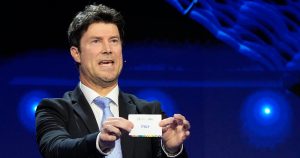 El exjugador de fútbol Brian Laudrup sostiene el papel con el nombre de Italia durante el sorteo para el Campeonato Europeo 2024 en Hamburgo, Alemania el sábado 2 de diciembre del 2023.(AP Foto/Martin Meissner)