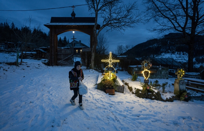 Un niño camina por un cementerio después de una misa por Navidad, en Kryvorivnia, Ucrania, el 24 de diciembre de 2023. Foto: Evgeniy Maloletka, AP