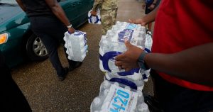 Voluntarios entregan botellas de agua a la gente en un centro de distribución en Jackson, Mississippi, el 7 de septiembre de 2022. Foto: Rogelio V. Solis, AP