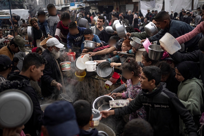 Palestinos hacen fila para recibir una comida gratuita en Rafah, en la Franja de Gaza, el 21 de diciembre de 2023.
