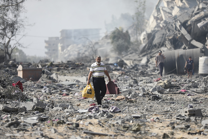 Palestinos caminan entre los restos de los edificios destruidos por los bombardeos israelíes en al-Zahra, a las afueras de la Ciudad de Gaza, el 20 de octubre de 2023.