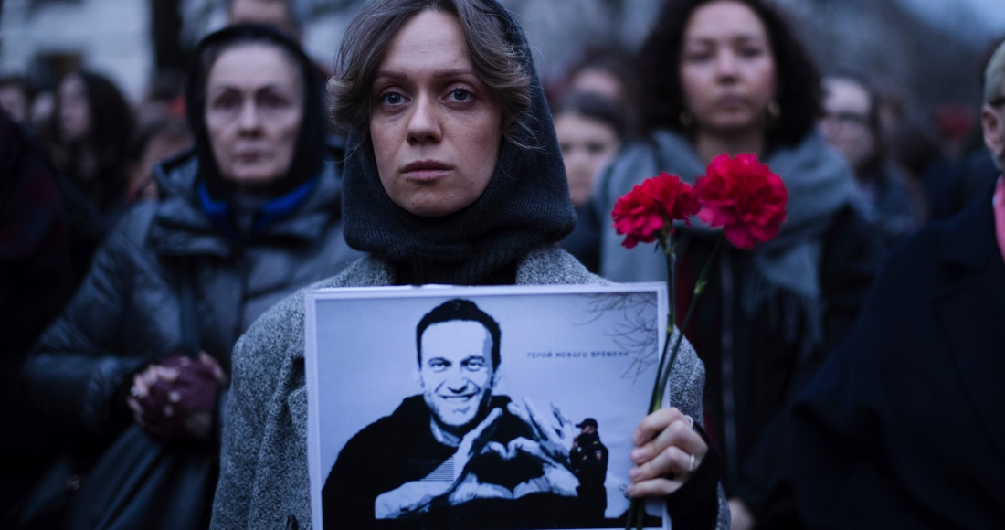Una mujer sostiene flores y un retrato del destacado opositor ruso Alexei Navalny durante una protesta frente a la embajada rusa en Berlín, Alemania, el viernes 16 de febrero de 2024, tras la noticia de su muerte estando en prisión en Rusia.