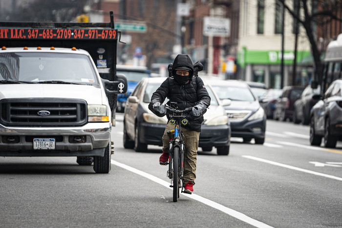 Un repartidor de comida en bicicleta circula hacia el norte por la avenida Flatbush el jueves 1 de febrero de 2024 en Nueva York.