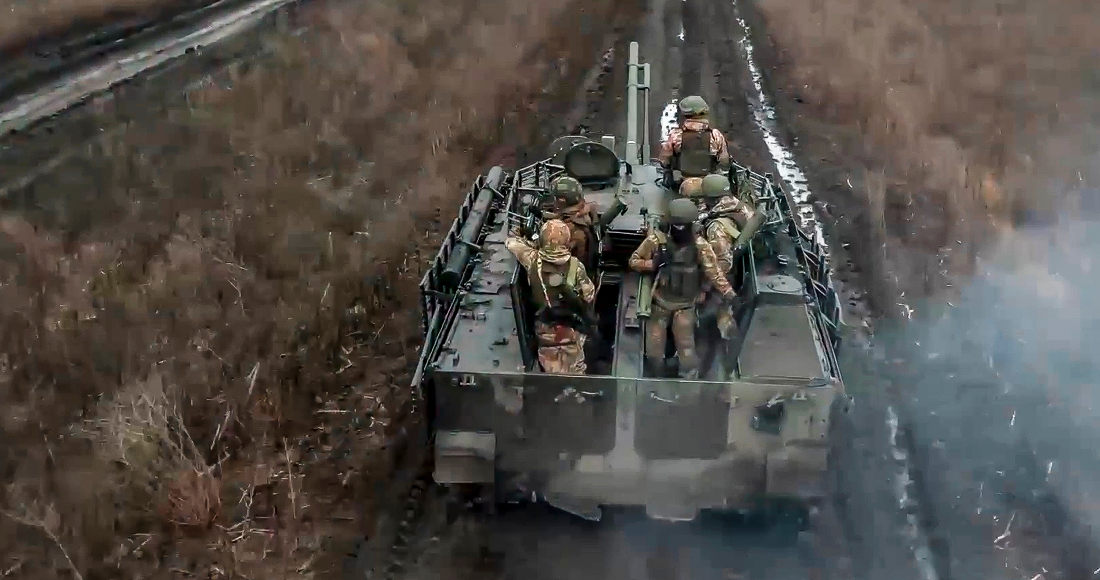En esta imagen tomada de un video distribuido por el servicio de prensa del Ministerio de Defensa de Rusia el 13 de abril de 2024, soldados rusos avanzan en un vehículo blindado para tomar posiciones y disparar contra posiciones ucranianas, en un lugar no identificado de Ucrania. (Servicio de prensa del Ministerio de Defensa de Rusia vía AP)