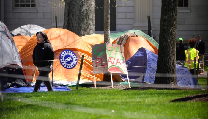 Una mujer camina junto a un campamento de protesta contra la guerra entre Israel y Hamás en Harvard Yard, en el campus de la Universidad de Harvard, el jueves 25 de abril de 2024, en Cambridge, Massachusetts.