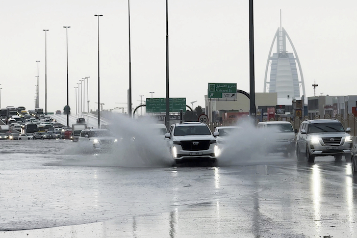 Una camioneta arroja agua a su paso por una carretera anegada, con el edificio Burj Al Arab, de fondo, en Dubái, Emiratos Árabes Unidos, el 16 de abril de 2024.