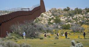 Un grupo de migrantes en la frontera entre Estados Unidos y México. Foto: Damian Dovarganes, AP.