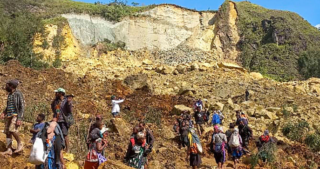 En esta imagen proporcionada por UNDP de Papúa Nueva Guinea, vecinos buscan entre los restos de un deslave en el poblado de Yambali, en las tierras altas de Papúa Nueva Guinea, el domingo 26 de mayo de 2024.
