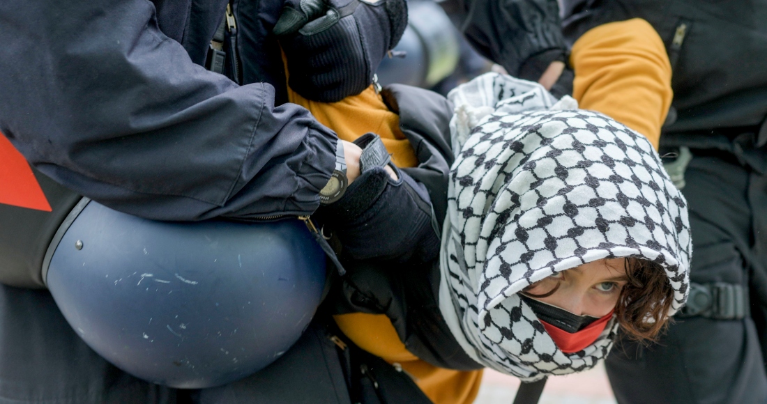 Una mujer es retirada por policías en una protesta propalestina del grupo "Coalición Estudiantil Berlín" en el patio de teatro de la Universidad Libre de Berlín, en Berlín, el martes 7 de mayo de 2024.
