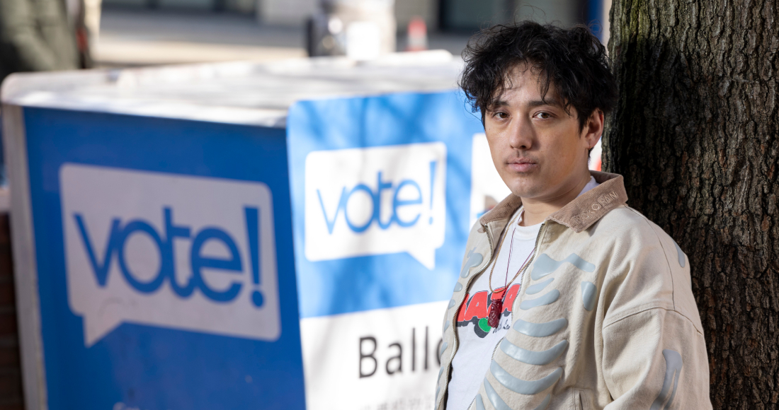 Kenji Takada-Dill, de 30 años, posa para una foto junto a un buzón en el que los votantes pueden dejar sus papeletas en el estado de Washington, en el que existe un programa de votación por correo, el miércoles 13 de marzo de 2024, en Seattle. 