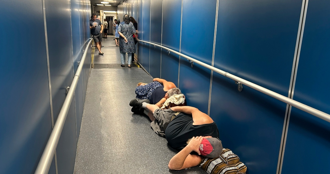 Viajeros en el Aeropuerto Internacional de Los Ángeles, duermen en un pasillo por una demora en un vuelo de United Airlines debido a una caída generalizada de internet global, el 19 de julio de 2024, en Los Ángeles. 