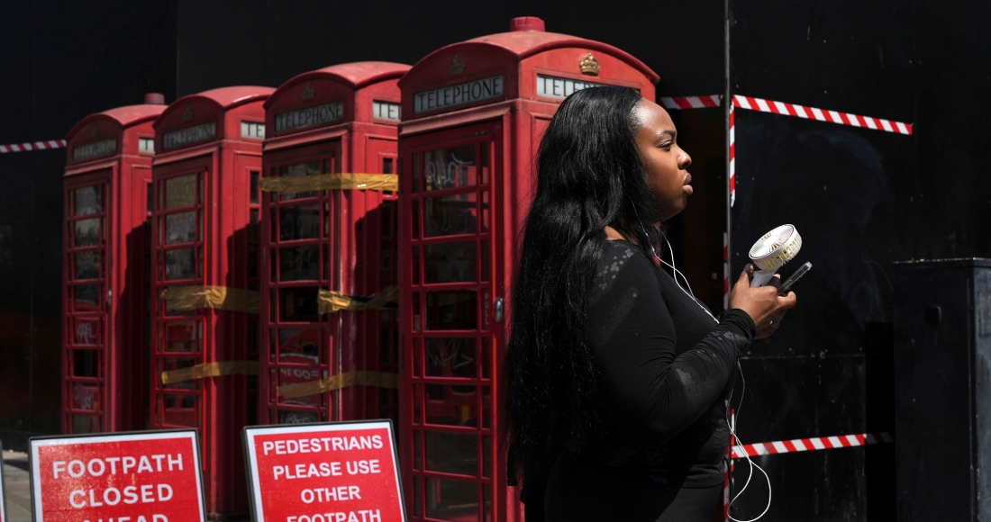 Una mujer se refresca con un ventilador de mano durante un día caluroso en Londres, el 26 