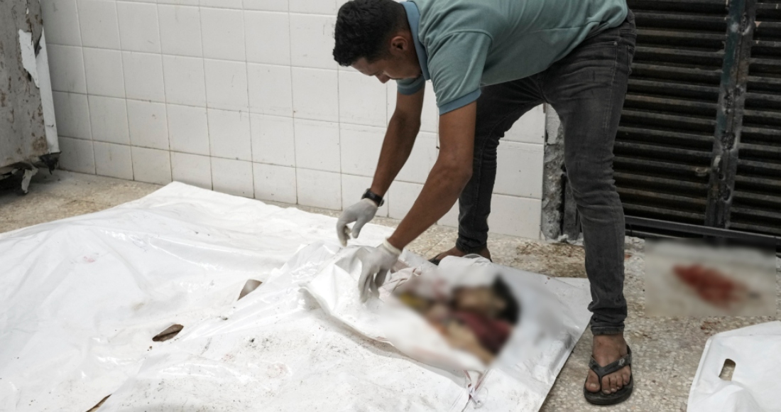 Un trabajador abre una bolsa para cadáveres para mostrar los de una familia palestina, formada por cinco niños de entre dos y 11 años y sus padres, en la morgue del hospital de los Mártires de Al-Aqsa, en Deir al-Balah, Gaza, tras un ataque israelí contra su casa en el campo de refugiados de Nuseirat, el 14 de agosto de 2024.
