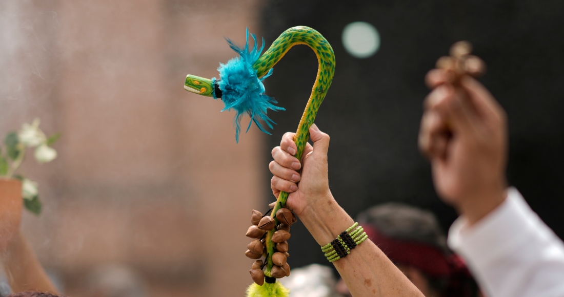 Una persona sostiene una figura de la serpiente emplumada Quetzalcóatl durante una ceremonia para conmemorar el 503 aniversario de la caída de la capital del imperio azteca, Tenochtitlán, en la Ciudad de México, el viernes de agosto de 2024.