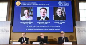 El secretario permanente de Ciencias, Hans Ellegren, en el centro, Jakob Svensson, a la izquierda, y Jan Teorell, de la asamblea del Nobel, anuncian el Premio del Banco de Suecia de Ciencias Económicas en Memoria de Alfred Nobel a Daron Acemoglu, Simon Johnson y James A Robinson, en la pantalla, durante una conferencia de prensa en la Academia Sueca de Ciencias en Estocolmo, Suecia, el lunes 14 de octubre de 2024.