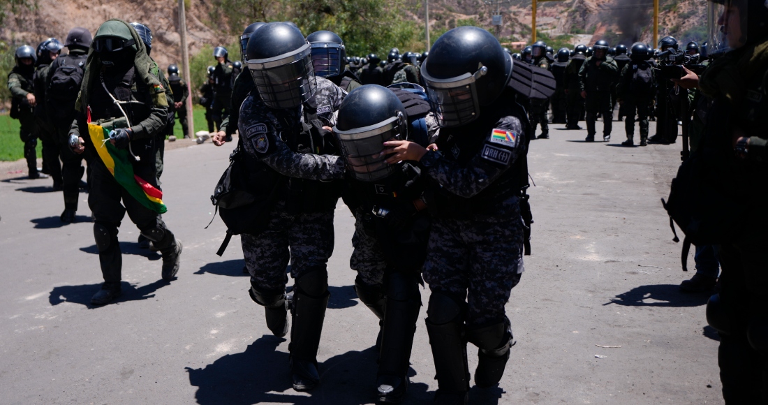 La policía ayuda a un compañero herido durante enfrentamientos con policías que trabajaban para despejar los bloqueos de carreteras instalados por partidarios del expresidente Evo Morales, para evitar que enfrente una investigación criminal por acusaciones de abuso de un menor mientras estaba en el cargo, en Parotani, Bolivia, el viernes 1 de noviembre de 2024.