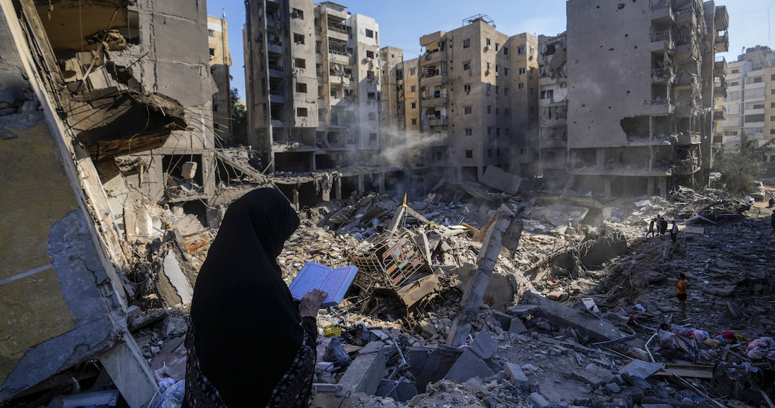 Una mujer lee el Corán en el lugar donde fue asesinado el líder de Hezbollah Hassan Nasrallah.