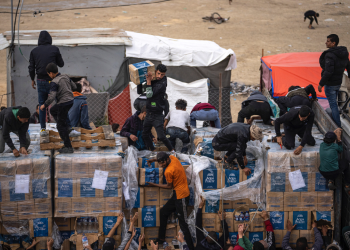 Palestinos descargan ayuda humanitaria de un camión en la Franja de Gaza.