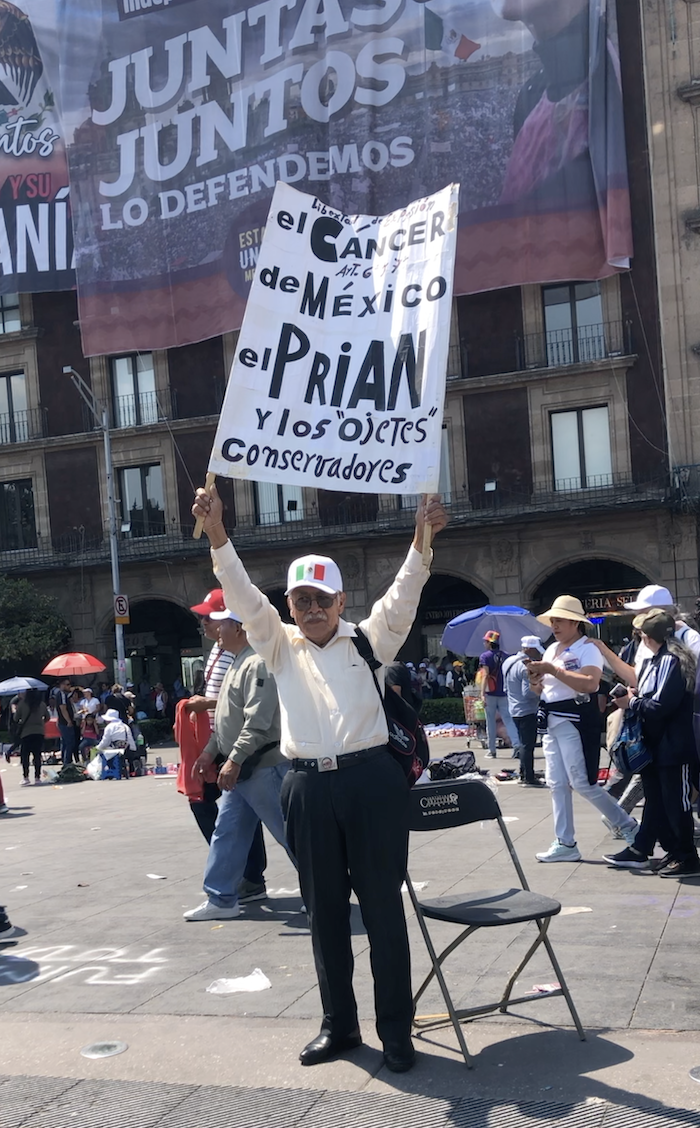 Un hombre de la tercera edad protesta en el Zócalo de CdMx el 9 de marzo, en la asamblea que encabezó la Presidenta Claudia Sheinbaum en el marco de las amenazas de EU por imponer aranceles.