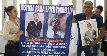 Los familiares de Erick Torbellín muestran una manta con la imagen del alumno fallecido donde exigen justicia.