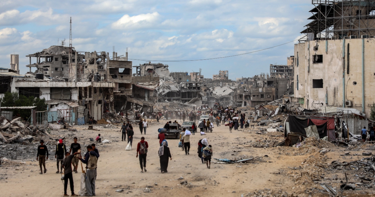 Palestinos caminan entre los escombros de los edificios destruidos tras regresar a Khan Younis, en el sur de la Franja de Gaza, el 12 de octubre de 2025.