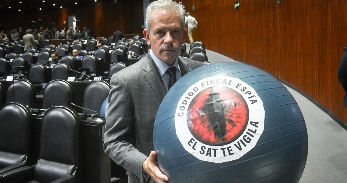 Marcelo Torres Cofiño, diputado del PAN, sostiene una pelota con la frase "Código Fiscal Espía".