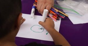 Boy drawing and learning in a classroom