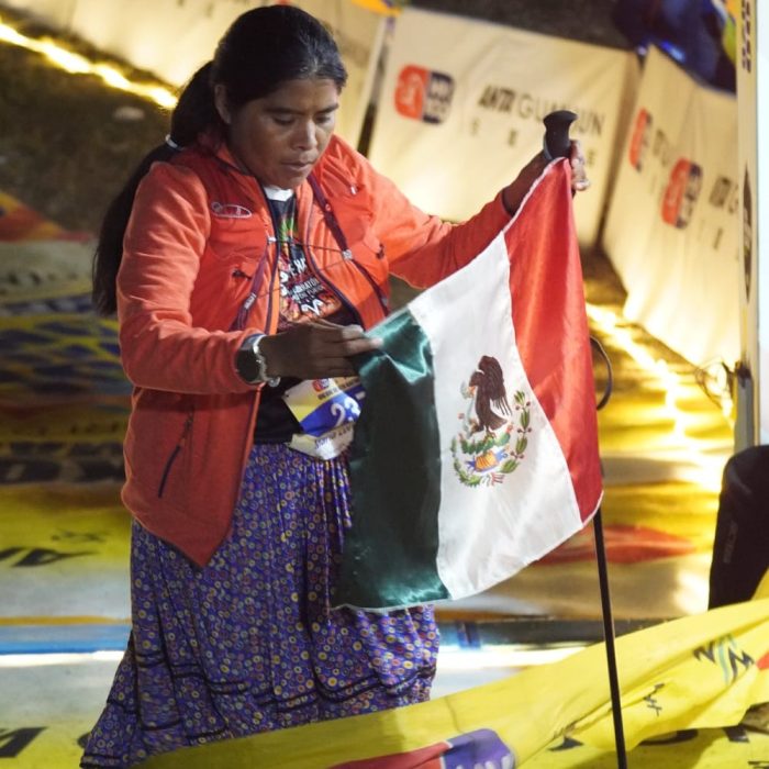 Lorena Ramírez con la bandera de México después de llegar a la meta del HK100