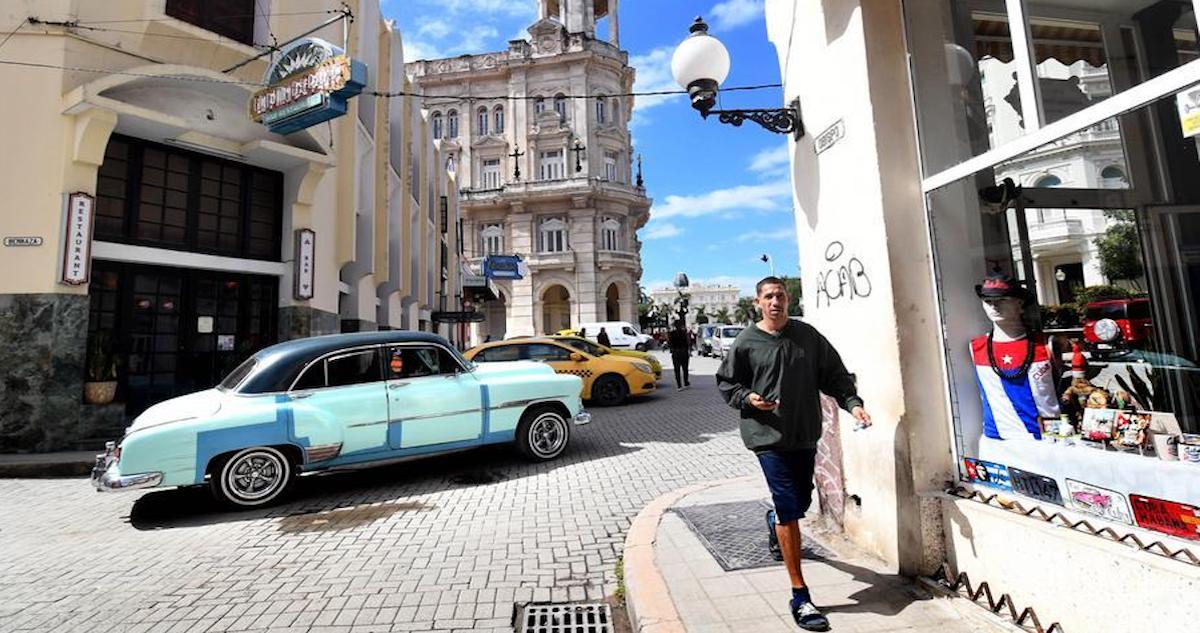 Un hombre camina mientras un automóvil antiguo circula por una calle en La Habana, capital de Cuba, el 7 de febrero de 2026.